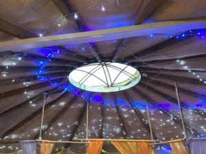 鲁特姆Vigo Retreat Yurt的天花板配有蓝色的灯光和吊灯