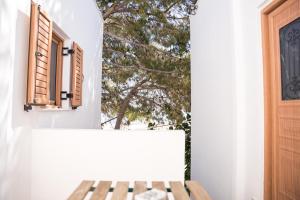 费拉Fira Central Budget Room and Kitchen的白色的房子,设有窗户和木凳