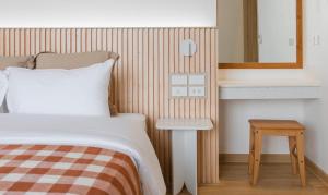 呵叻Punn Hotel Korat的一间卧室配有一张床、一张桌子和一面镜子