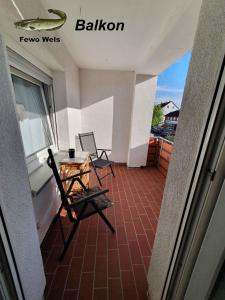 黑尔姆施泰特Fewo Helmstedt的阳台配有两把椅子和一张桌子,还有一个窗户。