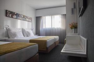 波瓦-迪瓦尔津绿色海岸酒店的酒店客房设有两张床和窗户。