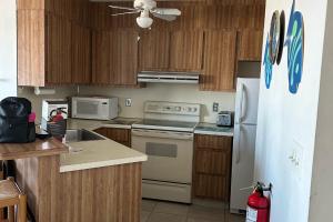 希塞德高地Sea Breeze Beach View的厨房配有木制橱柜和白色冰箱。
