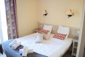 马莱莫尔Mazet Castel in Pont-Royal的卧室配有白色床和红色及白色枕头