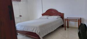 维多利亚-达孔基斯塔Apartamento completo e bem localizado的一间卧室配有一张带白色毯子和桌子的床。