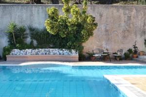 康托卡利Casa T with amazing views in Corfu的一个带桌椅的蓝色游泳池