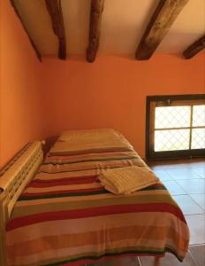 Vilella AltaCal Millo的橙色墙壁间的一张床位