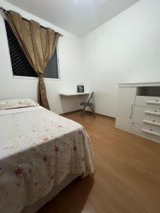 贝廷Apartamento aconchegante em Betim的一间卧室配有一张床、梳妆台和书桌