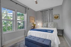 迈阿密海滩Stunning 2Bd 1Ba dream beach house in Surfside的一间卧室配有一张床和一个蓝色的搁脚凳