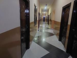 SpintexNABTEL HOTEL的走廊设有黑色门和白色瓷砖地板