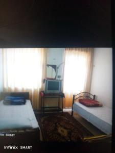 安曼Al Amawi Hostel的客房设有两张床、一台电视和窗户。