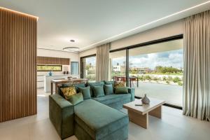 MódhionDeux Olives Luxurious & Quality Villa的一间带蓝色沙发的客厅和一间厨房