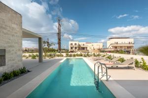 MódhionDeux Olives Luxurious & Quality Villa的一座带躺椅的游泳池位于大楼旁