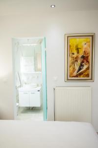 凯拉泰阿Keratea Luxury Villa -Athens Airport的一间带水槽的浴室和墙上的绘画