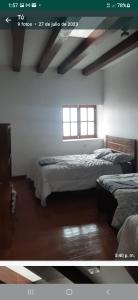 卡哈马卡Taita wasi的一间卧室设有两张床和窗户。