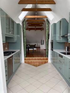 EllerauEllerau Home的一间设有绿色橱柜的厨房和一间用餐室