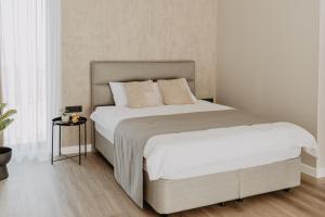 叶尔加瓦Cukura Loft的卧室配有一张带白色床单和枕头的大床。