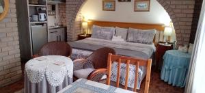 德班Lily's Cottage的一间卧室配有一张带两把椅子和一张桌子的床。