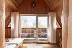 ManiowyChata Nad Jeziorem的木屋内设有一间带大窗户的卧室