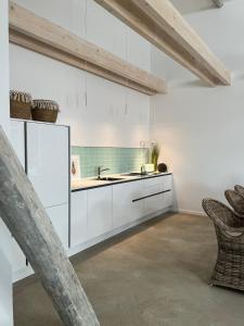 维岑多夫Sievershof Poolloft的厨房配有白色橱柜和水槽