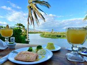 阿卡普尔科Hotel Boutique Punta Jamaica的一张桌子,上面摆放着食物和饮料,享有河景