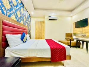 新德里Galaxy Stay Hotel Near Delhi Airport的一间卧室配有一张带红白毯子的床