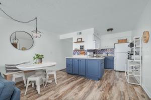 达克2971 - Seabbatical by Resort Realty的厨房配有蓝色橱柜和白色冰箱
