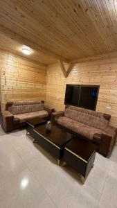 阿杰隆The Lodge Ajloun的客厅配有2张沙发和1台平面电视
