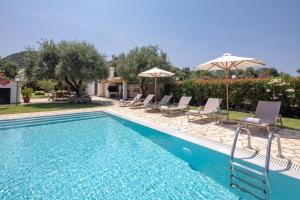 阿尔米罗斯海滩Skales Villas的庭院内带椅子和遮阳伞的游泳池