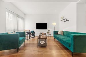 哈罗盖特Springfield Two的客厅配有两张绿色沙发和一台电视机