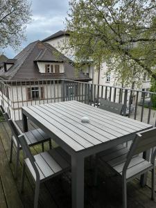 莱茵河畔路德维希港Living Apartments Ludwigshafen的甲板上的一张木桌和两把椅子