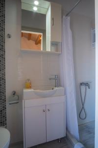 库卡里A window to the Aegean的白色的浴室设有水槽和镜子