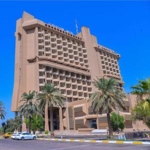 巴格达Almansour Hotel的一座棕榈树环绕的大建筑