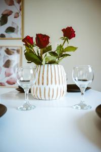 LoúkhiouEllafos Traditional Living的两杯旁的白色花瓶,上面有红玫瑰