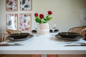LoúkhiouEllafos Traditional Living的白色的桌子,有两盘,花瓶