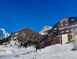 马索科托Maso Corto Alpine Adventure的一座雪中与山间的建筑