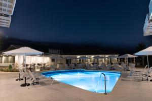 基督教堂市South Point Hotel的游泳池在晚上提供椅子和遮阳伞