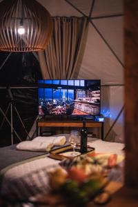 坎巴拉Glamping Atmosphera的一间设有一张床的房间和帐篷内的电视