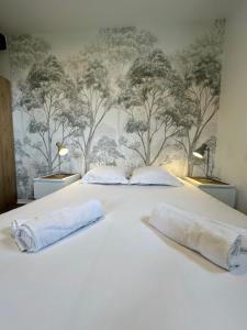CommesHôtel Restaurant le clos de l 'Ancien Pressoir的卧室配有白色床铺上的2个枕头