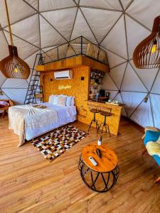 坎巴拉Glamping Atmosphera的帐篷内的卧室,配有一张床和一张桌子