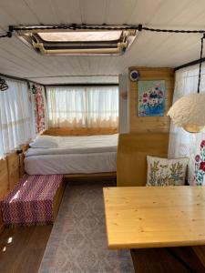 叶海格纳佐尔Crossway Camping的一间卧室配有两张床和一张位于拖车内的沙发。