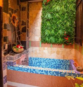 圣多明各Boutique Colonial House Hotel的瓷砖浴室设有植物浴缸
