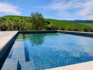 渥尔特拉Podere Santa Renata的庭院里的一个蓝色海水游泳池