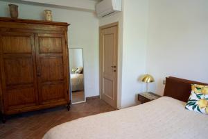 渥尔特拉Podere Santa Renata的一间卧室配有一张床、梳妆台和镜子