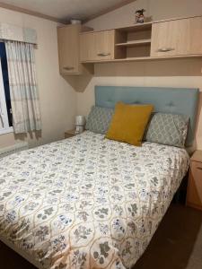 Lytchett MinsterRockley Park- Turlin Valley 36的一间卧室配有一张带蓝色和白色棉被的床
