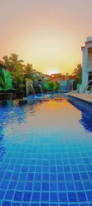坎多林Luxury 3BHK Villa With Swimming Pool in Candolim的蓝色的游泳池,背景是日落