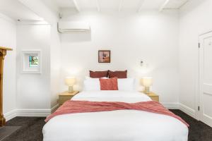 奥克兰Beautiful Spacious 3BR的卧室配有一张白色大床和两盏灯。