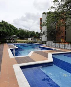 卡利Apartamento en Cali Inn tropical CLO的地面上一个蓝色瓷砖的大型游泳池
