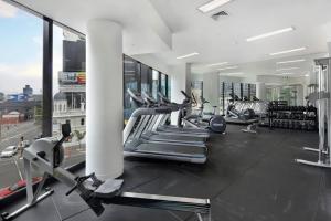 墨尔本A Modern & Spacious 2BR Apt City Views Southbank的健身房设有数台跑步机和有氧运动器材