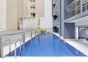 悉尼A Comfy 2BR Apt Amazing View of Darling Harbour的建筑物一侧的游泳池