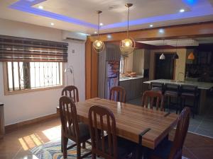 阿库雷An Entire Rare Stylish 5-Bedroom Bungalow的厨房以及带木桌和椅子的用餐室。